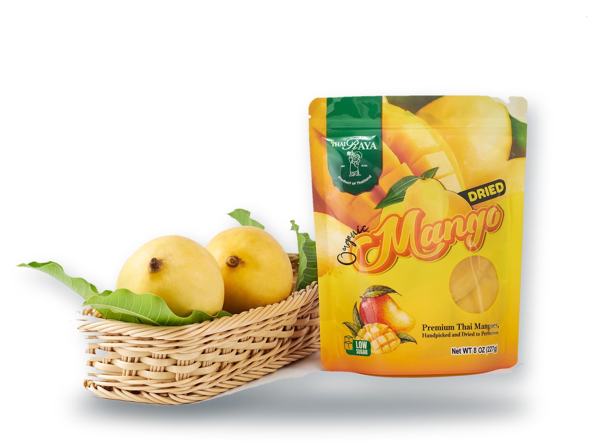 Fresh Thai mangoes in a basket beside a pouch of Thairaya organic dried mango
